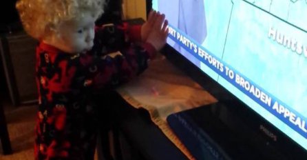 Preslatki dječak pokušava zaustaviti slova 'kako ne bi pobjegla' s ekrana