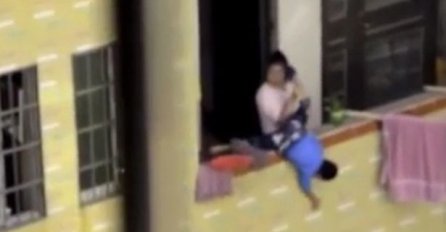 Ljuta majka vrišti na svoje dijete i diže ga preko ograde balkona dok komšije gledaju i snimaju
