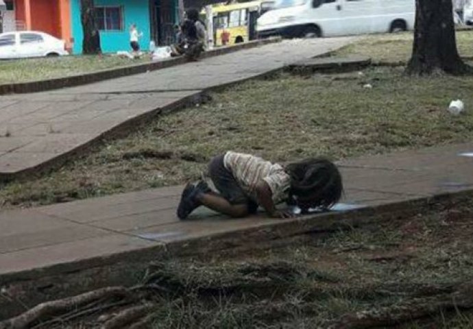 OVA FOTOGRAFIJA JE POSRAMILA SVIJET: Siromašna devojčica pije vodu iz bare na zemlji (FOTO)