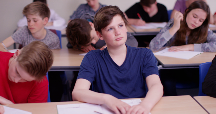 4k-school-boy-day-dreaming-beside-his-classmate-in-classroom-st7ja-lx-f0000