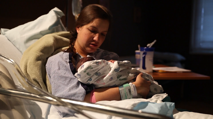 a-woman-holding-newborn-baby-in-hospital-bed-4yjxvnmsvx-f0000
