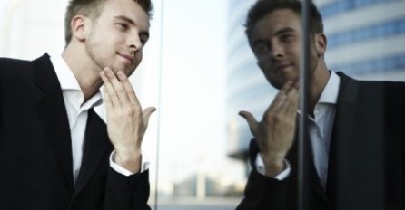 Stoji muž pred ogledalom,  dotjeruje , posmatra ga...