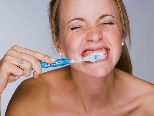 woman-brushing-her-teeth-smiling-close-up