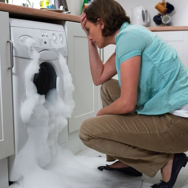 woman-looking-at-broken-washing-machine