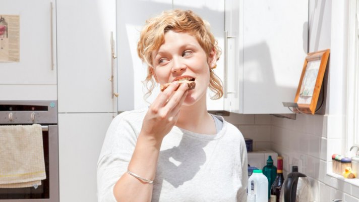 young-woman-eating-toast-in-kitchen-1296x728-header
