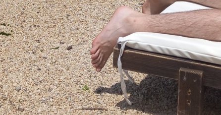 SLIKA SA PLAŽE POSTALA NAJVEĆI HIT: Muškarac se sunča, ali svi gledaju samo 1 DETALJ - PLAKAT ĆETE OD SMIJEHA kad vidite cijelu sliku(FOTO)