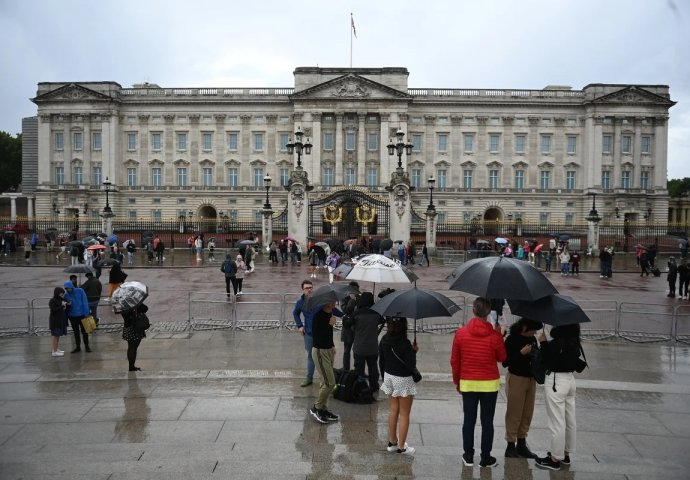 Građani pristižu i ispred Buckinghamske palače u Londonu, čekaju vijesti na kiši